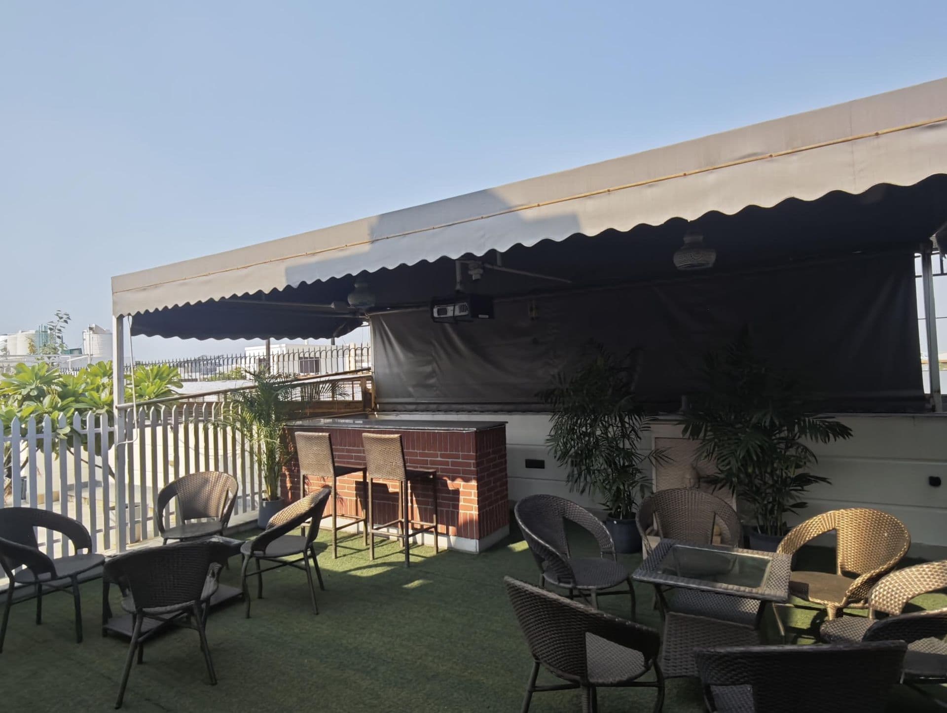 Podcasts, interviews and video shoots at Terraza de Fiesta GK2: The brick bar, high stools and awning on the sunlit terrace