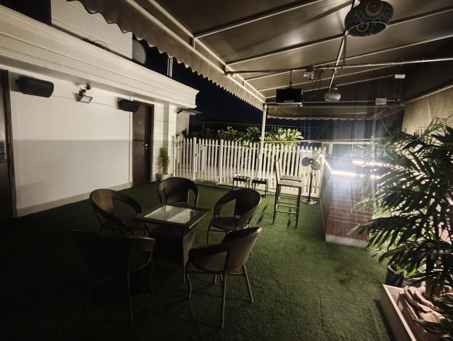 Networking mixers and founder meetups at Terraza de Fiesta GK2: The terrace with the bar, seating and projector under the canopy